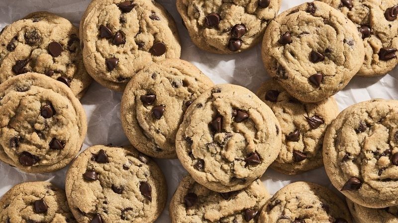 Flera gyllenbruna chocolate chip-kakor med varierande sprickig yta